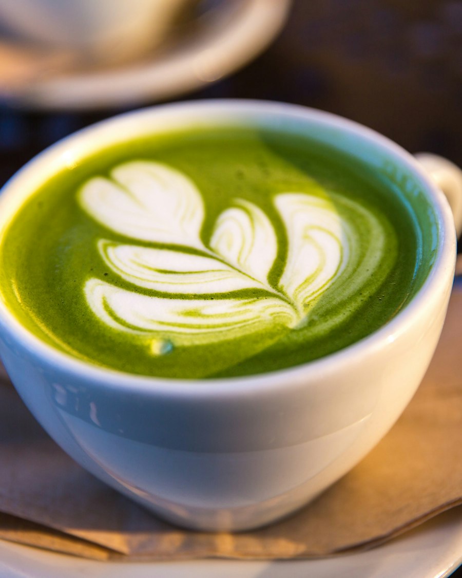 Matcha latte with leaf latte art in a white cup